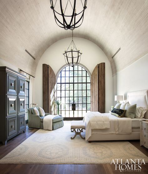 The 18-foot barrel-vault ceiling in the master bedroom is more dimensional thanks to antique-finished wooden boards. Judy Long, a decorator friend of Lisa and Michael, devised the solution for arched door shutters for privacy and to protect from harsh lighting. Shutters Repurposed Decor, Barrel Vault Ceiling, Black Curves, Atlanta Homes, Tuscan Style, White Box, Spanish Style, Living Room Paint, Beautiful Bedrooms