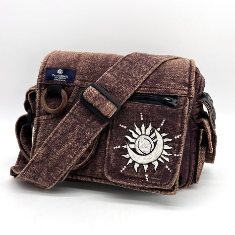 Lukla Brown Stone-Washed Sunmoon Embroidered Messenger Bag This Is A Compact Yet Voluminous Bag. Along With Its Multiple Pockets Used For Storage, It Includes A Large Flap Closure With Velcro. Starting Off With The Two Front Pockets, Open Up The Flap To Find The Main Compartment Following The Large Extra Pocket, And Even A Cute Mini Side Pocket! Make Travel Hands-Free With This Spacious Bag. Not Only Is This Bag Sustainable And Eco-Friendly, But Made Of Heavy Cotton Outside, Lined With Cotton In Messenger Bag Shop, Fantasy Messenger Bag, Brown Side Bag, Messager Bags Aesthetic, Messenger Bag With Pins, Traveler Clothes, Thrift Accessories, Sewed Bags, Messenger Bag Aesthetic