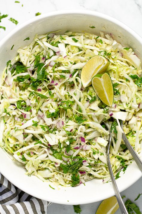 This Cilantro Lime Slaw is the perfect addition to any taco! Crisp, crunchy, and, tangy, it comes together in about 5 minutes and is loaded with all real ingredients - and NO MAYO! This slaw is tossed in a Mexican-inspired lime vinaigrette which leaves it tasting light, zesty, and refreshing! Cilantro Lime Coleslaw, Slaw For Tacos, Lime Coleslaw, 7 Day Cabbage Soup Diet, Lime Slaw, Cilantro Lime Slaw, Cabbage Soup Diet, Lime Vinaigrette, Broccoli Slaw