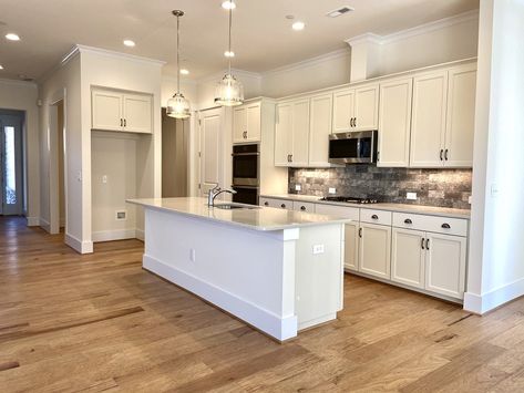 How to Create a Warm White Kitchen - Niblock Homes Kitchen Flooring Ideas With Maple Cabinets, Kitchen Floor White Cabinets, White Kitchen Light Wood Floors, How To Warm Up A White Kitchen, White And Bronze Kitchen, Kitchen Ideas Classic, Warm White Kitchen, Taupe Flooring, White Kitchen Wood Floors