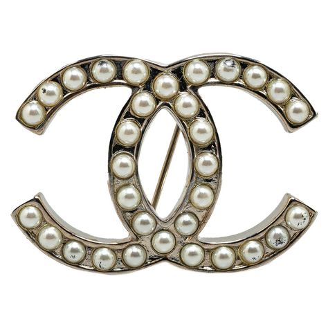 Maak kennis met de prachtige Chanel CC Faux Pearl Brooch, een verfijnde knipoog naar iconische vintage stijl. Deze Franse schat straalt pure elegantie uit met zijn zilverkleurige metalen structuur, versierd met symmetrisch geplaatste faux parels. De klassieke dubbele C-vorm omarmt de kenmerkende luxe van Chanel en voegt een vleugje tijdloze charme toe aan elke outfit. Hoewel de broche wat karakter vertoont met lichte gebruikssporen, blijft het een gewild object onder vintage modefans. Met een breedte van 4 cm en een lengte van 3 cm is het een subtiele maar krachtige aanvulling op je sieradencollectie. Voeg deze schoonheid toe aan je verzameling en draag een stukje modegeschiedenis bij je.