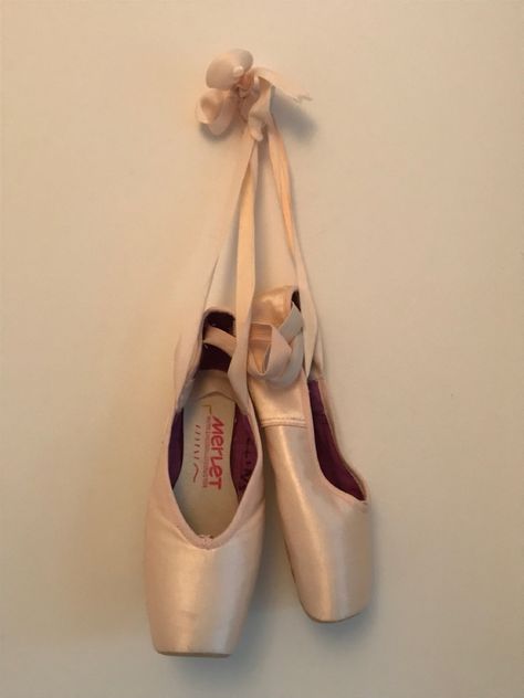 Pair of pointe shoes hanging on a white wall. Hanging Pointe Shoes, Old Pointe Shoes Display, Pretty Pointe Shoes, Ballet Brochure, Pointe Shoes Aesthetic, First Pointe Shoes, Pointe Shoes Photography, Ballerina Pointe Shoes, Point Shoe