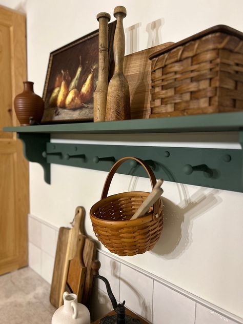 Add character and functionality to your space with this handcrafted, pine wood peg shelf. Wooden shaker peg shelf with hand crafted corbel ends. Pictured in Basil Green 36" (5 peg), this is a versatile shelf that provides both character and functionality to your space. The accent ends on our shelves are hand crafted and not something that can be purchased in a big box store. Each piece is built and painted by hand in our shop. Variations in wood grain make each piece slightly different which add Shaker Peg Rail Entryway, Shelf Picture Display, Amazing Gray Paint, Shaker Peg Shelf, Shaker Shelf, Green Farmhouse Kitchen, Dining Room Shelf, Peg Coat Rack, Old Shelves