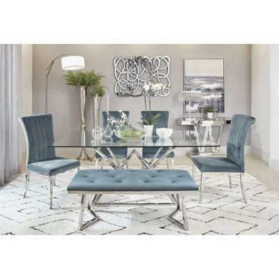 With an Art Deco flair, this six-piece dining set comes complete with a spacious table, four chairs, and a bench. The table features an angular, geometric base in a shiny chrome finish as well as a thick tempered glass tabletop with a softly beveled edge. Each of the four chairs offer a channel tufted, rolled back and the bench offers a padded, button tufted seat. These upholstered pieces are wrapped in a soft dark grey velvet with sleek flared legs that mimic the table base finish. This stunnin Glass Dining Table Set, Серая Кухня, Glass Top Dining Table, Trestle Dining Tables, Grey Dining, Coaster Furniture, Dining Room Set, Contemporary Dining, Glass Dining Table