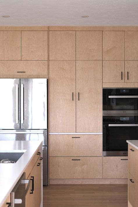 This light-filled project in Omaha, NE 🇺🇸, features Plykea Maple and Fenix Bianco Kos kitchen fronts, with edge banded cover panels and a mix of black edge pull and D pull handles.   #plywoodkitchen #birchplywood #plywood #ikeahack #kitchenideas #kitchentrends #fenixforinteriors #maple  Design: IKD - Inspired Kitchen Design Oak Kitchen Black Handles, Plykea Kitchen, Modern Maple Kitchen, Birch Plywood Cabinets, Flat Front Kitchen Cabinets, Flat Panel Kitchen Cabinets, Ply Kitchen, Inset Kitchen Cabinets, Kitchen Laminate