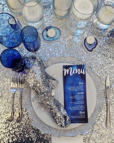 Sweetheart Table Details. This Place Setting Displays Silver Sequin Tablecloth & Napkins, Silver Reef Charger Plate, Silver Gem Napkin Ring, Custom Blue Agate Wedding Dinner Menus, Blue Agate Candle Holders, Blue Glassware And Floating Candles Snowflake Dinner Party, Blue And Silver Dinner Table Setting, Blue Silver Table Decor, Blue White Silver Birthday Decorations, Blue And Silver Event Decor, Blue Silver Christmas Table, Disco Dinner Party Table, Blue Birthday Dinner Decor, Blue And Silver Table Decorations