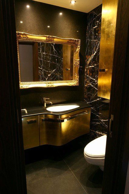 a luxurious powder room with black walls, chic gold touches, a gold vanity, some built in lights and white appliances Gold Bathroom Decor Ideas, Black And Gold Bathroom Decor, Black Powder Room, Gold Bathroom Set, Modern Powder Rooms, Modern Powder Room, Gold Bathroom Decor, Black And Gold Bathroom, Bathroom Decor Colors