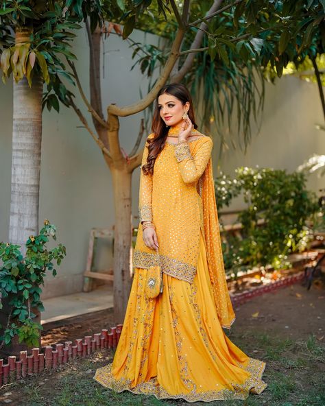 GULAAL is a classic majestic look, well suited for formal occasions. This beautiful Mustard yellow sharara is adorned with reverie like embellishments, rendered in a glowing pearl, gotta and zardozi work. Paired with gorgeously accented flowy raw silk sharara with motif spray and adorned borders. The elegant look is completed with an chunri chiffon dupatta, adding details of kiran lace, to make it an ideal festive wear. #festive #traditional #SN #snatelie #chunri #mehendi #launchingsoon Raw Silk Sharara, Yellow Sharara, Silk Sharara, Zardozi Work, Adding Details, Chiffon Dupatta, Festive Wear, Raw Silk, Festival Wear