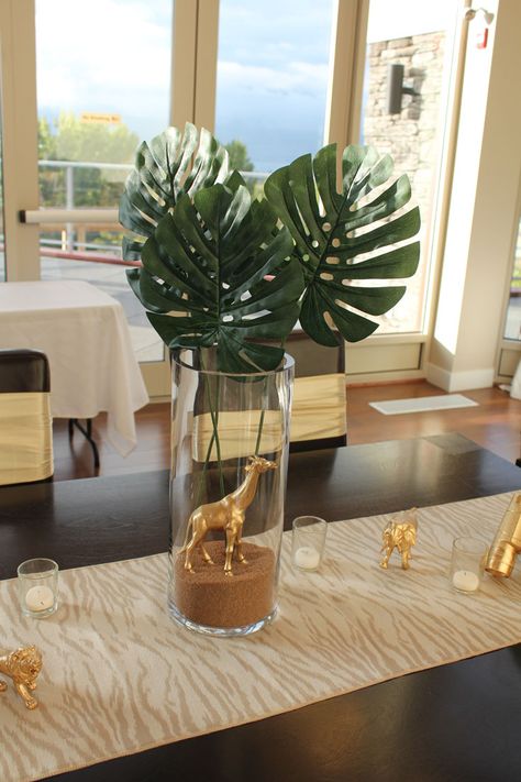 glass vase with palm leaves and gold giraffe at baby shower Safari Centerpieces, Tropical Decorations, Gold Safari Baby Shower, Safari Baby Shower Decorations, Wild Baby Shower, Safari Baby Shower Boy, Baby Shower Safari, Jungle Thema, Baby Shower Safari Theme