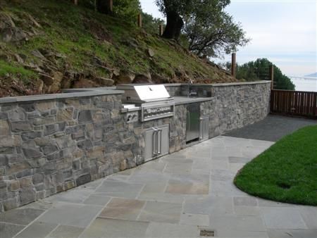 Bluestone Retaining Walls | After- Manufactured Stone Veneer Retaining Wall, Outdoor Kitchen Retaining Wall Outdoor Kitchen, Bbq Built Into Retaining Wall, Outdoor Kitchen Retaining Wall, Stone Veneer Retaining Wall, Wall Fence Ideas, Hawaii Backyard, Fence Retaining Wall, Farm Patio, Retaining Wall Fence