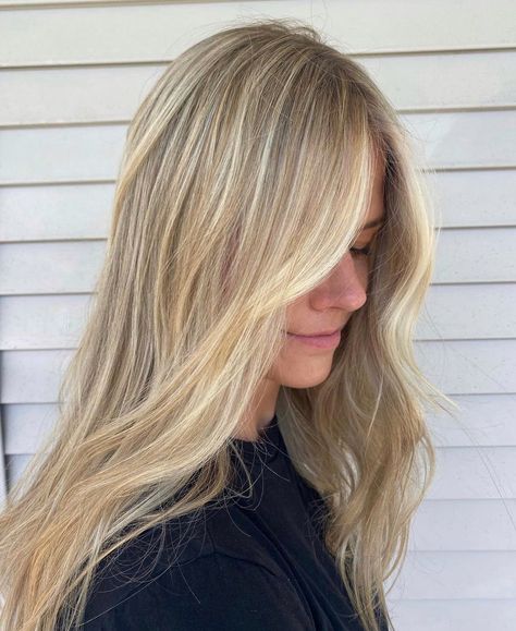 A girl looking down wearing a black t-shirt showing off her new salon hair. She has loosely curled beach waves and bright blonde highlights on dark blonde hair. The highlights are heavier at the front and there is a bright blonde money piece. Neutral Tone Blonde Highlights, Natural Beachy Blonde, Blond Balayage Medium Length, Full Blond Highlights, Full Head Honey Blonde Highlights, Balayage With Babylights Blonde, Scandi Blonde Highlights, Blonde Hilights With Money Piece, Full Foil Highlights Blonde With Money Piece