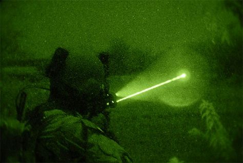 An American Special Forces soldier uses an infrared laser pointer and illuminator device mounted on his rifle to scan for enemy activity during a night op in Afghanistan.  Devices such as the PEQ-15 emit an infrared or visible search light and/or aiming device.  When wearing Night Vision Goggles (NVGs), the user can use the infrared modes to search and area / point at a target without giving away their position to non-nvg-equipped enemy. Beret Aesthetic, American Special Forces, Ghost Soldiers, Combat Arms, Night Vision Goggles, Military Aesthetic, Between Two Worlds, Green Beret, Laser Pointer