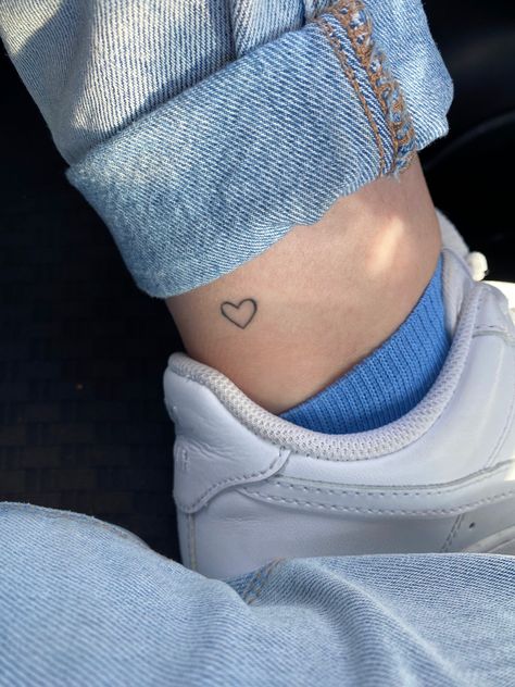 Tiny Blue Heart Tattoo, Simple Heart Tattoo Designs Ideas, White Tattoo Heart, Leg Heart Tattoo, Simplistic Heart Tattoo, Fine Heart Tattoo, Small Heart Tattoo Placement, Heart On Ankle Tattoo, Heart Foot Tattoo