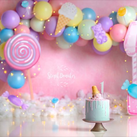 Candyland themed cake smash set. The backdrop is pink, and there's a bright balloon garland with purple, pink, blue and yellow balloons. Lots of candy scattered around the set, and an ice cream themed cake! Birthday Theme For Photoshoot, Sweet One Birthday Balloons, Candy Land Theme Photoshoot, Candyland Birthday Photoshoot, Two Sweet Party 2nd Birthday Photoshoot, Candyland Smash Cake, Candyland Theme Photoshoot, Sweet One Photoshoot Baby, 2nd Year Birthday Ideas Girl