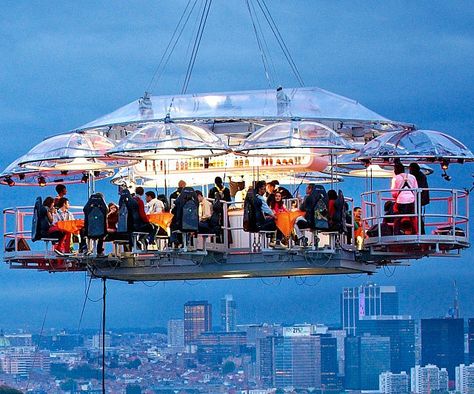 Dine amongst the clouds like the gods by celebrating your next event aboard this suspended dinner table. You and your closest friends will be treated to five star dining while enjoying a breathtaking view of the cityscape below - just don't drop your steak knife. Hanging Restaurant, Dinner In The Sky, Unique Restaurants, Interesting Stuff, Beautiful Places To Visit, Breathtaking Views, Insta Travel, The Sky, Places To Travel