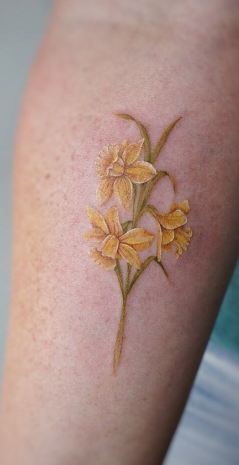 Daffodil Tattoos: Meanings, Tattoo Designs & Ideas Tattoos Daffodil, Yellow Flower Tattoos, Narcissus Tattoo, Daffodil Flower Tattoos, Narcissus Flower Tattoos, Yellow Tattoo, Mum Tattoo, Daffodil Tattoo, Bouquet Tattoo