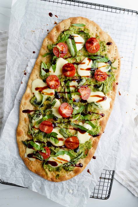 A savory dish inspired by the Italian Caprese salad, this flatbread is topped off with melted mozzarella, juicy cherry tomatoes, and tangy pesto sauce. Flatbread Meals, Quick And Easy Flatbread Recipe, Flat Bread Wraps, Caprese Flatbread, Tomato Flatbread, Italian Caprese, Italian Caprese Salad, Mozzarella And Tomato, Easy Flatbread Recipes