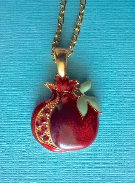 This necklace has a beautiful pomegranate in a rich red color. it is hand-painted on a gold plated base and measures 1" tall not counting the gold loop.  with the loop it s 1 1/4" tall.  the width is 7/8" wide.  there are three pearlized leaves  and along the left side there are six red swarovski crystals along the other side. the chain is gold filled. Funky Gold Necklace, Pomegranate Accessories, Gold Aesthetic Jewelry, Necklaces Aesthetic, Etsy Necklace, Apple Necklace, Pomegranate Necklace, Pomegranate Jewelry, Red Necklace