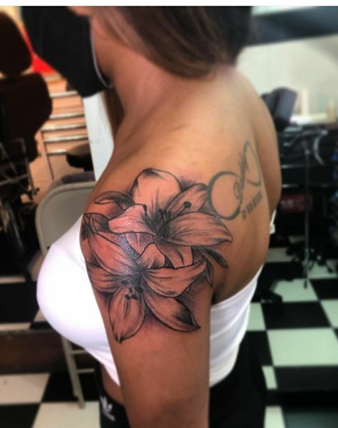 Tulip Tattoo Shoulder, Hibiscus Flower Tattoos Black Women, Tulip Tattoo On Leg, Lilly Tattoo Black Women, Beautiful Shoulder Tattoos, Black Women Flower Tattoos, Lilium Flower Tattoo, Lilly Tattoo On Shoulder, Lily Flower Tattoos Shoulder