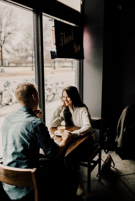 Engagement pictures of two people holding hands while looking at each across a table drinking coffee. Coffee Shop Wedding Photos, Couples Cafe Photo, Coffee Shop Prewedding, Coffee Shop Prenup, Pre Wedding Shoot In Cafe, Coffee Date Pictures, Cafe Couple Photoshoot, Coffee Shop Photoshoot Ideas, Cafe Engagement Photos