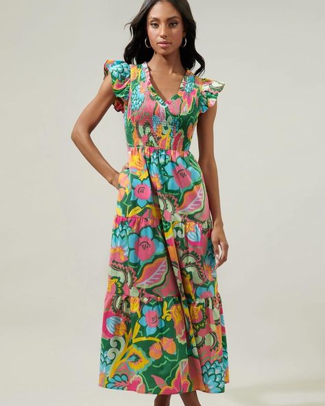 If the life of the party were a dress, this would be it. This multicolored tropical floral print works to decorate the Sunfire dress. Lightweight cotton allows you to do your thing all day. It features a flattering smocked bodice with a ruffle V neckline, framed by ruffle cap sleeves. It maintains a fit and flare silhouette with a tiered maxi skirt! ❤️TROPICAL SUNFIRE Floral Smocked Bodice Tiered Midi Dress ($88)❤️ #silveraccents #summer #shoplocal Tropical Party Dress, Boutique Outfits, Bag Patches, Do Your Thing, Fit And Flare Silhouette, Tiered Maxi Skirt, Tropical Floral Print, Tropical Party, Tiered Midi Dress