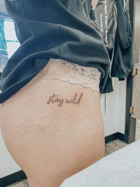 stay wild tattoo Stay Wild Hip Tattoo, Wild Love Tattoo, Wild As Her Tattoo, Keep Her Wild Tattoo, Stay Wild Buttcheek Tattoo, Stay Wild Tattoo Ideas, Rebellious Tattoos For Women, Wild Tattoo Word, Wild One Tattoo