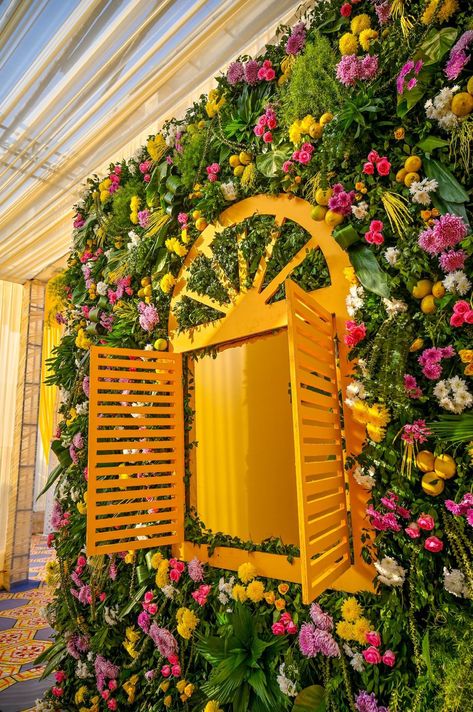 Peep out of the window hugged with deep fragrance of exotic flowers was an amazing experience for every excited guest. Haldi Selfie Booth, Selfie Point Ideas, Event Decor Business, Mehendi Theme, Haldi Theme, Shadi Decor, Haldi Shoot, Floral Entrance, Haldi Ideas