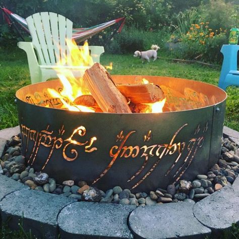 This fire ring is straight out of the mystical world of LOTR. Made of steel, this ring is perfect for that backyard dinner in the winters. Place it as a decor piece in your home to flaunt your eternal LOTR Fandom! It’s going to make a lot of fans jealous! Lotr Fire Pit, Lord Of The Rings Fire Pit, Burn Barrel Ideas Fire Pits, Covered Fire Pit, Permanent Campsite, Backyard Circus, Diy Fire Pit Ideas, Burn Barrel, Cordwood Homes