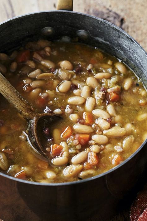 Ina Garten's Tuscan White Bean Soup is made with cannellini beans, pancetta, leeks, onions, carrots, celery, garlic, rosemary, chicken stock, and Parmesan cheese. This hearty Tuscan White Bean Soup recipe creates a delicious dinner that takes about 2 hours , including soaking time, to prepare and can serve up to 6 people. Ina Garten Tuscan Bean Soup, Ina Garden Tuscan White Bean Soup, Ina Garten Tuscan Soup, Ina Garten Vegetable Soup, Garlic Bean Soup, Ina Garten Tuscan White Bean Soup, Cannellini Bean Soup Recipes, Ministroni Soup Recipe Ina Garten, Tuscan Bean Soup Recipe