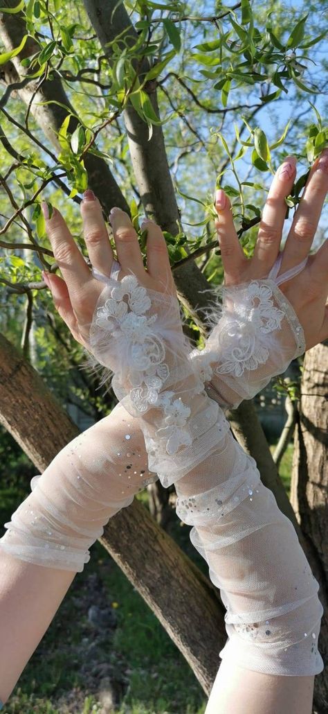 I made this gleaming bridal gloves using elastic shimmering tulle, sewing it on my sewing machine. Then I attached the lace by hand. The gloves are fingerless and fits most. >>--------------------------------------> ❤This gloves are in stock and ready to ship.  Shipping times can vary greatly depending on location. >>--------------------------------------> The length 40cm Hand wash recommended! Do not bleach Do not tumble dry Do not dry clean ------------------------------------------ To see more, please click on this link: https://www.etsy.com/shop/HaniKRaft?section_id=32131878 --------------------------------------------------- Custom orders are always welcome. Scroll up and click >>request a custom order<< link :) and get something unique for yourself now! ------------------------------ Tulle Gloves Wedding, Cinderella Gloves, Princess Gloves Aesthetic, Mermaid Gloves, Tulle Fingerless Gloves Wedding, Fairy Gloves, Tulle Sewing, Bridal Gloves Long, White Fancy Gloves