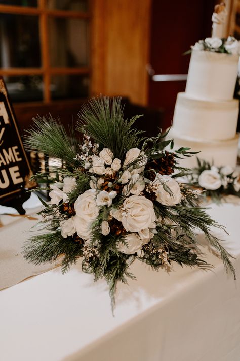 Pinecones, white roses, evergreen, pine bouquet Winter Wedding Floral Decor, White Christmas Bouquet, Evergreen Wedding Centerpiece, Evergreen Centerpiece Wedding, Pine Wedding Bouquet, Pine Centerpiece Wedding, Evergreen Bridal Bouquet, Pine And Roses Centerpiece, Pine And Rose Bouquet