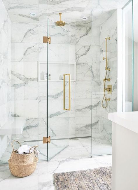 Luxurious white and gray marble shower with a white niche enclosed with glass doors and brass hardware. Marble Shower Tile, White Marble Bathrooms, Marble Showers, Real Estat, Bad Inspiration, Hospital Interior Design, Diy Shower, Gray Marble, Bathroom Remodel Shower