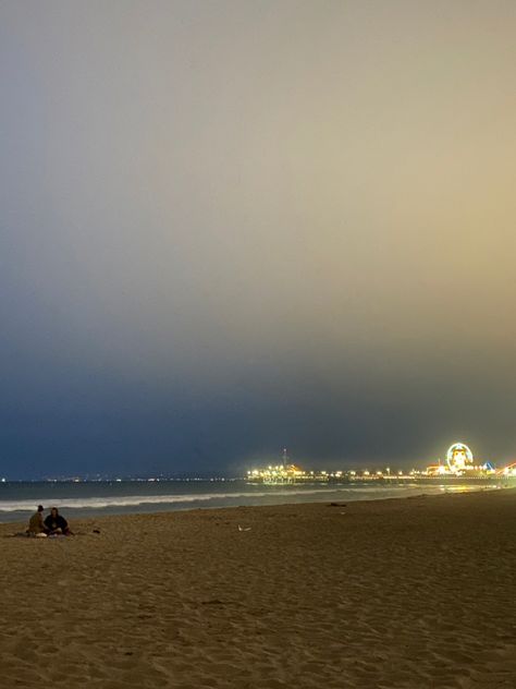 Santa Monica beach at 8:41 pm in the summer time. There’s still  light out so the sky is a bit foggy.  The fog makes it look like and old camera quality. You can see the pier and there’s a couple sitting on the sand . The pier is in the background. Santa Monica Instagram Pictures, Santa Monica Beach Aesthetic, Santa Monica Aesthetic, La Beach, Miss California, Beach At Night, Santa Monica Beach, California Vibe, Beach Night