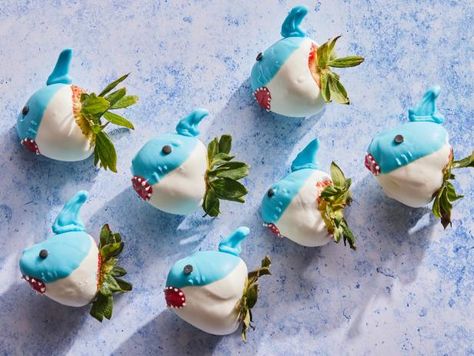 It’s time to get ready for the most 'jawsome' week of the year: Shark Week! If you’re anything like us you’ve already started stocking up on viewing party essentials—which makes this the perfect time to start planning your menu. Whether you’re leaning towards a showstopping shark cake, an entire school of shark-themed cupcakes or savory snacks that everyone will want to sink their teeth into, you’ll find all the recipes you need right here—starting with these fun chocolate-dipped strawberries. They come together quickly and are easy to make. For the most “sharky” look, we suggest choosing large, stem-on strawberries that are just a bit flat at the tip (versus very pointy). To prevent condensation, refrigerate the little sharks for no more than 2 hours before serving—or chomping! Shark Themed Food For Adults, Shark Strawberries, Shark Treats, Shark Themed Food, Pumpkin Cheese Ball Recipe, Shark Week Recipes, Ice Cream Sundae Recipe, Shark Week Party, Sundae Recipes