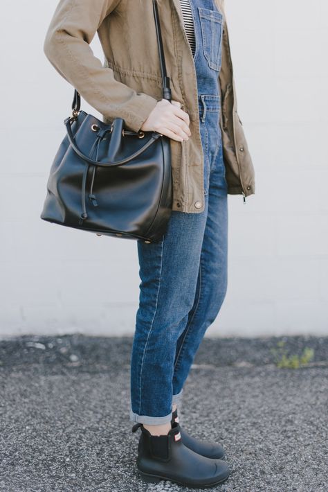 Overalls outfit. Hunter Chelsea boots. Bucket back. Ysl. Green parka. Casual outfit. Overalls With Chelsea Boots, Chunky Rain Boots Outfit, Chelsea Hunter Boots Outfit, Hunter Ankle Boots Outfit, Hunter Short Boots Outfit, Hunter Chelsea Boots Outfit, Short Rainboots Outfit, Short Hunter Boots Outfit, Overalls Outfit Fall