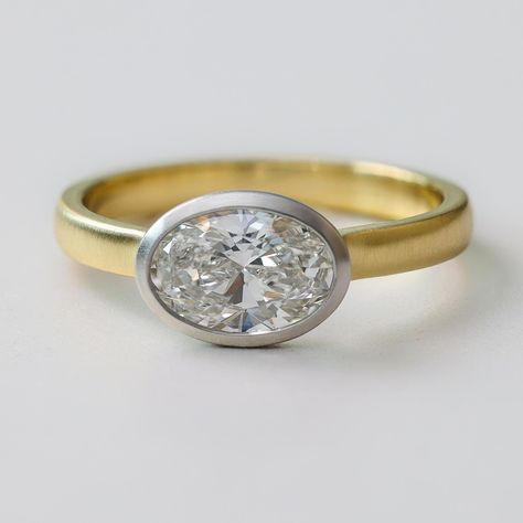 Introducing "Juni", a modern and minimalistic East-West Oval Diamond Engagement Ring. Expertly crafted in New York City, this low-set ring is designed for everyday wear without compromising on style. The oval diamond, set in a brushed two-tone metal bezel, exudes sophistication while the low-profile setting ensures practicality and comfort. Shown in the listing picture and video with 1 carat oval diamond. We can set this with any stone shape and size so contact us for a quote. If you want natura East West Bezel Engagement Ring, Low Profile Engagement Ring, Low Profile Engagement Rings, Bezel Engagement Ring, Oval Diamond Engagement, Oval Diamond Engagement Ring, Set Ring, Oval Cut Diamond, Diamond Set