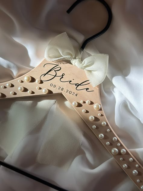 *orders with pearl hangers will included an envelope of extra pearls *  Introducing our personalized pearl wedding hangers, the perfect accessory to add a touch of elegance and sophistication to your big day. These hangers are not just functional but also serve as a beautiful keepsake for years to come. Each hanger can be personalized with the name or initials of the bride, bridesmaid, groom, groomsmen, flower girl, mother of the bride, or mother of the groom, making them a thoughtful and meanin Diy Wedding Hangers Bridesmaid, Wedding Day Hangers, Wedding Day Accessories Brides, Bridesmaid Proposals Unique, Pearl Hangers Wedding, Bride Hanger Diy, Bride To Be Accessories, Mother Of The Bride Ideas, Bride Gifts From Bridesmaid