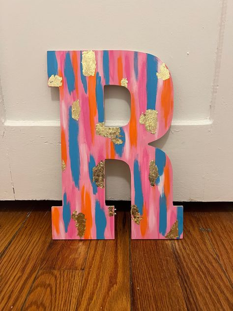 This is a colorful letter from your choice of letter with beautiful colors and cold flakes that stand out! Perfect for dorm rooms! Cute Wood Letter Painting Ideas, Smear Painting Canvas, Dorm Room Diy Decor, Painted Initial Letters, Dorm Room Paintings Canvases, Letter A Painting, Sorority Letters Painted Wooden, Painting Ideas Preppy, Sorority Painted Letters