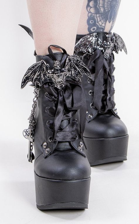 For the tall countesses and vampire lords! The Poison 107s are the most extra platforms for creatures of the night: these comfortable wedges are covered in studs n straps to kill, topped off with bat wings and a bat charm over the laces. Vegan Black PU leather 5 inch platform Bat wing ankle bootie Bat charm Studded straps Side zip Studded heel Removable chain with charms Ribbon lace-up U.S women's sizing-refer to size chart for more info Black Goth Shoes, Gothic Accessories Jewellery, Chain With Charms, Goth Outfit Inspo, Formal Ideas, Demonia Boots, Black Vampire, Vampire Clothes, Alternative Shoes