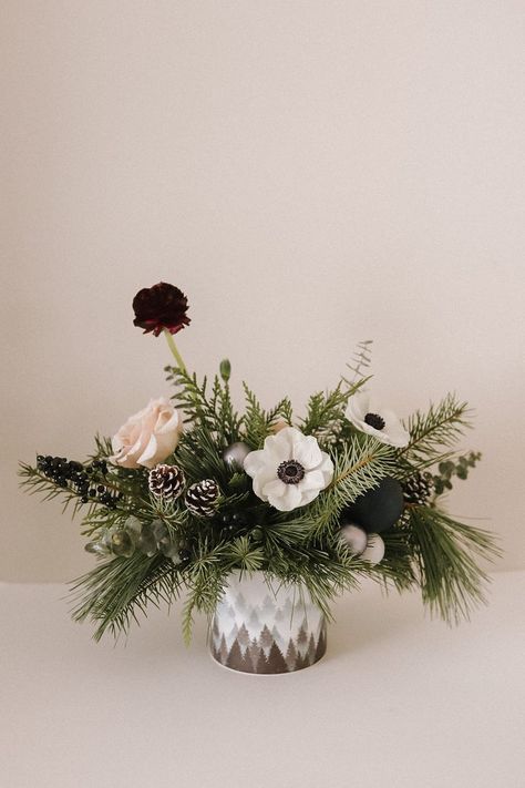 This warm and festive arrangement is a made up of anenome, quicksand roses, mini pinecones and winter greens. It's paired perfectly with a misty mountain pot. Order here: https://bloomfloral.ca/collections/holiday-flowers/products/mountain-morning Mini Pinecones, Holiday Flower Arrangements, Christmas Centrepieces, Winter Flower Arrangements, Winter Wedding Centerpieces, Winter Greens, Winter Arrangements, Winter Bridal Showers, Best Match