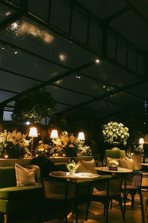 Stylish lounge setup featuring green sofas and lush floral arrangements under a glass tent. Cozy Wedding Ideas, Cozy Wedding Reception, Green Sofas, Reception Lighting, Wedding Reception Lighting, Wedding Ambiance, Cozy Wedding, Dinner Setting, Romantic Wedding Receptions