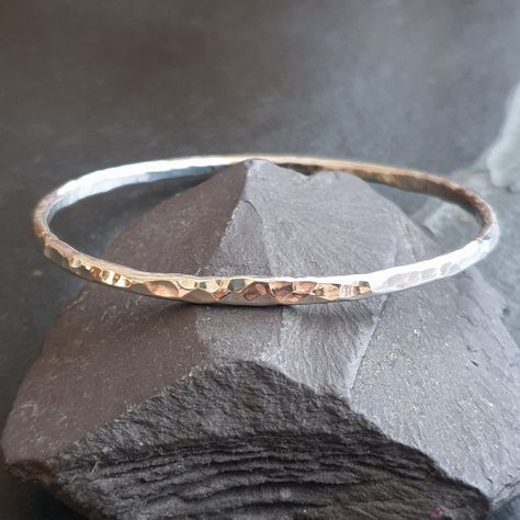 This hammered silver bangle is handmade from sturdy solid silver wire which has been given a heavy dimple texture making a unique piece of organic jewellery. It has been polished to a high shine and reflects the light beautifully! This beaten metal bangle would look great worn as a stacking bangle with your other favourites and would make a lovely, classic jewelry gift. The dimple bracelet is currently available in a small - 60mm diameter, medium - 65mm diameter, large - 70mm diameter or extra large - 75mm diameter. Other sizes can be made to order, please contact me for turnaround time.  The last photo shows a guide on how to measure your hand for a bangle size. If you're buying as a gift, medium tends to fit most.  Metal thickness: 3mm Currently a round shape, but all my bangles can be r Hammered Silver Bracelet, Silver Bangle, Hammered Silver Jewelry, Hammered Jewelry, Hammered Bangles, The Bangles, Bangles Making, Bracelets Design, Organic Jewelry