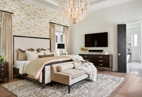 This amazing master bedroom was part of a whole house remodel by Haven Design and Construction.  The gold and white geometric wallpaper accent wall is a showstopper.  The custom bedding, luxurious drapery, gold and glass chandelier, and beautiful furniture make it a true master bedroom retreat. Wallpaper Ideas 2023, Black White And Gold Bedroom, White Gold Bedroom, Bedroom Wallpaper Accent Wall, Bedroom Wallpaper Ideas, Decorating Hacks, Dining Room Accents, Transitional Bedroom, Bedroom Wallpaper