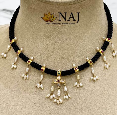 Black thread necklace embellished with 22k gold motifs adorned with rubies, emeralds, cz stones and pearls by NAJ Jewellery. Thread Jewellery Gold, Black Beads Nallapusalu, Pearl Black Beads Chain, Black Thread Gold Jewellery, Black Thread Jewellery Indian, Festive Black Beads Necklace For Puja, Beads Jewelry Indian Gold, Black Round Beads Necklaces For Puja, Naj Jewellery