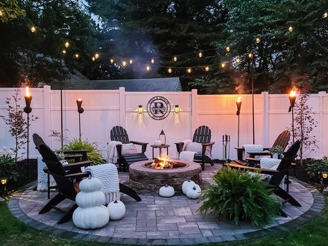 Create a cozy backyard oasis with Adirondack chairs around a lit fire pit! String lights and torches illuminate the space, while a white fence, pumpkins, and greenery add a festive touch. Backyard Oasis Ideas, Pools Backyard, Backyard Renovations, Easy Landscaping, Backyard Remodel, Backyard Inspiration, Have Inspiration, Backyard Inspo, Backyard Fire