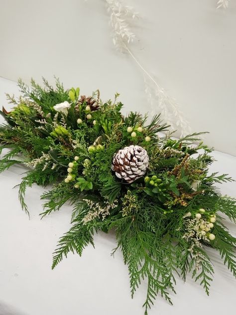 a table centrepiece with winter greens, berries and pine cones. Pine Centerpiece, Traditional Christmas Baking, Winter Table Centerpieces, Christmas Centre Pieces, Christmas Centrepieces, Winter Flower Arrangements, Winter Wedding Table, Winter Greens, Christmas Centers