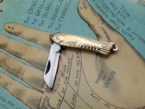 Miniature Fish Knife Charm - Tiny Retro Folding Shiny Brass Knife 🔪 #EDCKnifeBeads #KnifeAccessories #EverydayCarry #EDC #GearCustomization #TacticalBeads #ParacordBeads #HandcraftedBeads #ArtisanBeads #KnifeCollecting #KnifeEnthusiast #GearUpgrade #UniqueBeads #FunctionalArt Fish Pocket Knife, Funky Gifts, Creative Fashion Photography, Pretty Knives, Inside My Bag, Paracord Beads, Paracord Keychain, Fish Knife, Heart Emoji