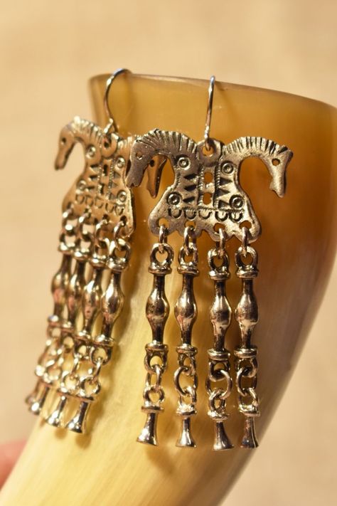 Long chandelier earrings - Viking double headed horses. Handmade sterling silver 925 or bronze earrings, inspired by ancient Norse jewelry. Great statement piece - bright but heavy earrings with charms. More about these earrings you can find in our Etsy shop SecretJewelryDesigns. #statementjewelry #vikingjewelry #horseearrings #handmadejewelry #statementearrings #animaljewelry #norsepaganjewel Norse Earrings, Viking Horse, Earrings With Charms, Viking Jewellery, Long Chandelier, Norse Jewelry, Norse Pagan, Horse Earrings, Heavy Earrings