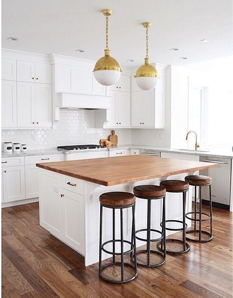 Stunning kitchen features a pair of Small Brass Hicks Pendants illuminating a white center island topped with butcher block lined with backless wood and iron counter stools. Kitchen Island Butcher Block Top, Kitchen Butcher Block Island, Island With Butcher Block Top, Kitchen Island With Butcher Block Top, Hickory Wood Floors, Kitchen Butcher Block, Butcher Block Kitchen Island, Butcher Block Island Kitchen, Butcher Block Island