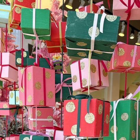 Seaside Papery Coronado on Instagram: "Guess how many!? Jori painted, glittered, ribboned and strung over 300 gift-box presents to make our whimsical, *season of giving* window display! 🎁 We’ve already got our next trick up our sleeve for January, so if you haven’t checked out this beauty in person, stop on by!" Stacking Presents Display, Ribbon Window Display, Wrapped Christmas Presents Display, Christmas Present Window Display, Christmas Window Display Artwork, Anthropologie Christmas Display Shop Windows, Christmas Toy Store Window Display, Gift Store, Window Display